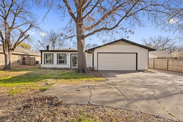 view of front of house with driveway, a chimney, a garage, and fence