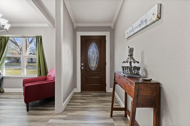 foyer with crown molding, wood finished floors, baseboards, and a textured wall