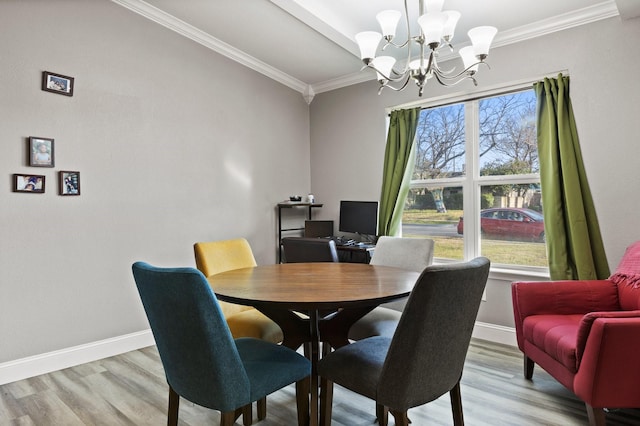 dining room featuring light wood-style flooring, an inviting chandelier, crown molding, and baseboards