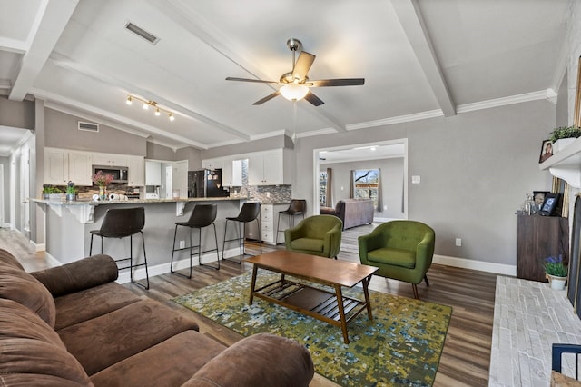 living area featuring light wood-style floors, lofted ceiling with beams, a fireplace, and visible vents