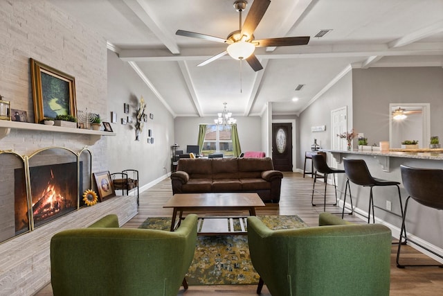 living area with lofted ceiling with beams, wood finished floors, a fireplace, and visible vents