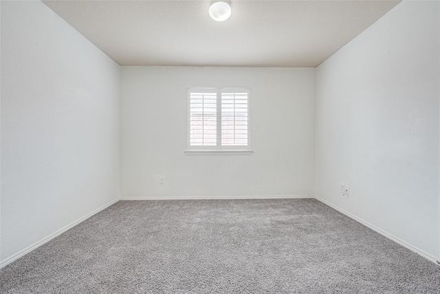 carpeted empty room with baseboards