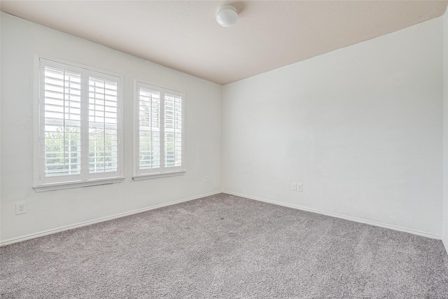 carpeted spare room with baseboards