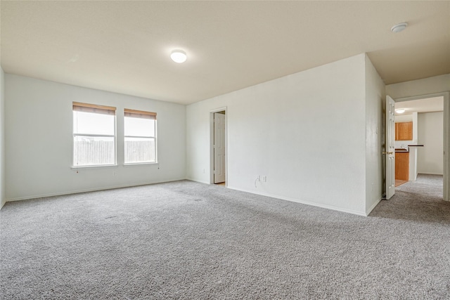 carpeted spare room featuring baseboards