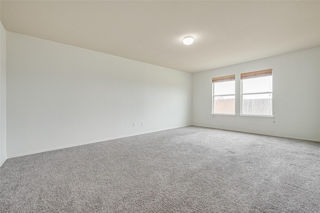 spare room with baseboards and carpet