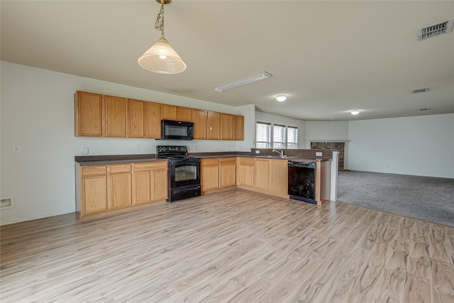 kitchen featuring visible vents, black appliances, dark countertops, open floor plan, and a peninsula