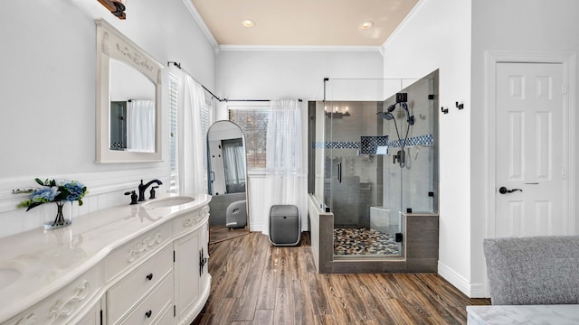 bathroom featuring a shower stall, vanity, crown molding, and wood finished floors