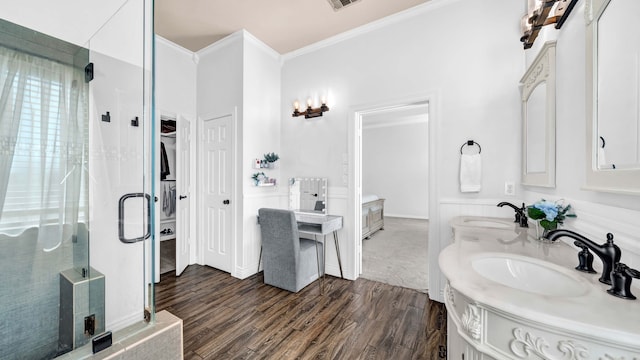 bathroom with a sink, a stall shower, wood finished floors, and ornamental molding