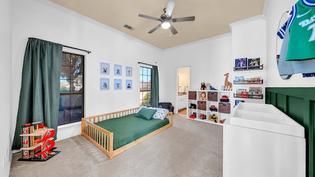 bedroom featuring ensuite bath, carpet flooring, visible vents, and ornamental molding