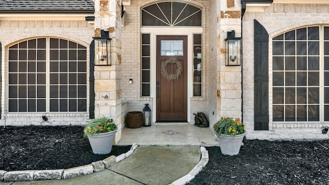 property entrance featuring stone siding and roof with shingles