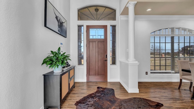 foyer entrance featuring wood finished floors, baseboards, decorative columns, recessed lighting, and crown molding