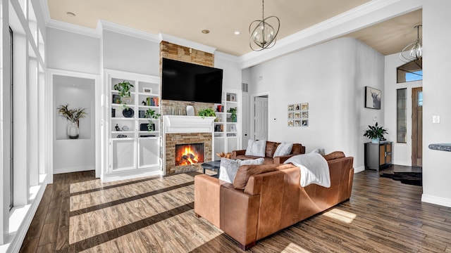 living room featuring a chandelier, ornamental molding, baseboards, and wood finished floors