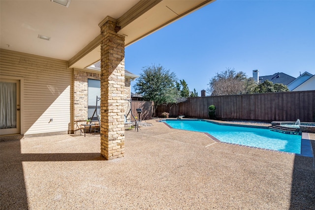 view of pool featuring a patio, a fenced backyard, and a pool with connected hot tub