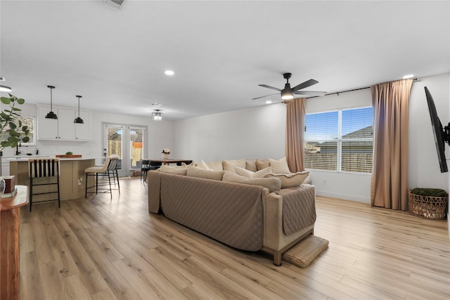 living area with recessed lighting, baseboards, light wood-type flooring, and ceiling fan