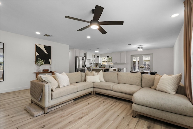living area with visible vents, baseboards, recessed lighting, light wood-style flooring, and a ceiling fan