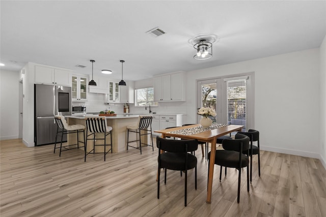 dining area featuring visible vents, baseboards, and light wood-style floors