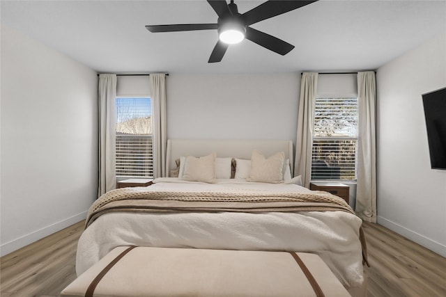 bedroom featuring a ceiling fan, wood finished floors, and baseboards