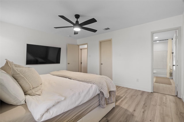 bedroom with light wood finished floors, visible vents, ceiling fan, baseboards, and ensuite bathroom