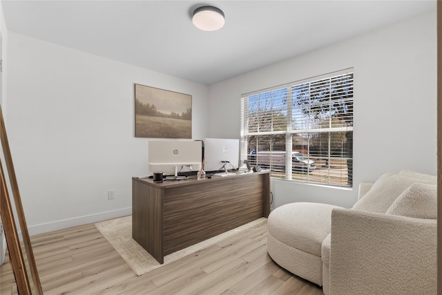 home office with light wood-type flooring and baseboards