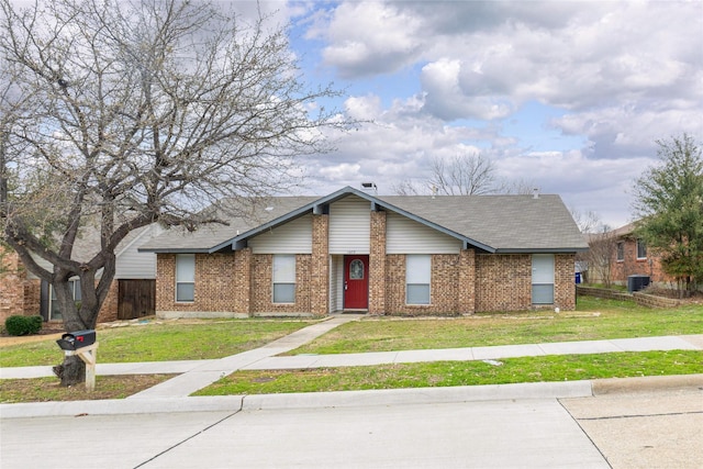 view of front facade with brick siding, central AC, a front yard, and a shingled roof