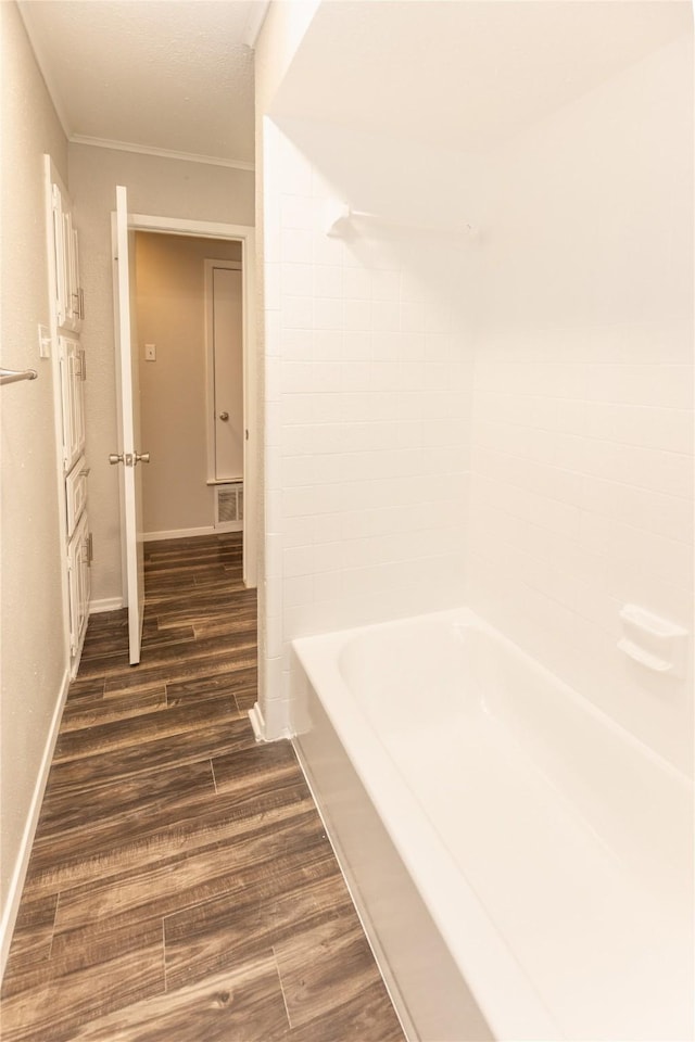 bathroom featuring visible vents, baseboards, wood finished floors, and crown molding