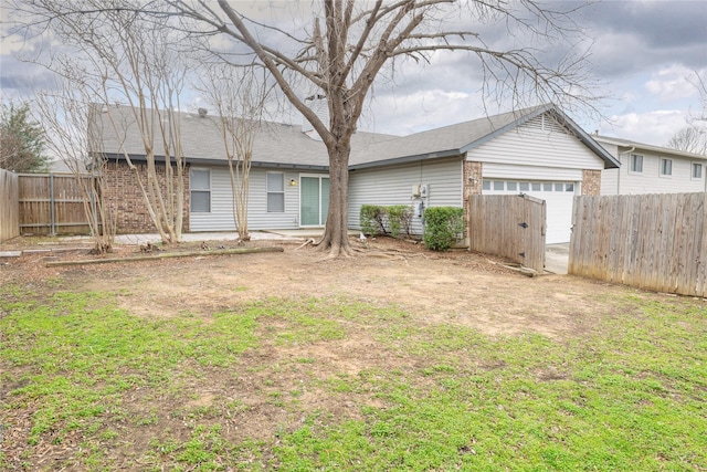 back of house with brick siding, an outbuilding, a garage, and fence