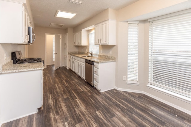 kitchen featuring white cabinets, appliances with stainless steel finishes, dark wood-type flooring, and a sink