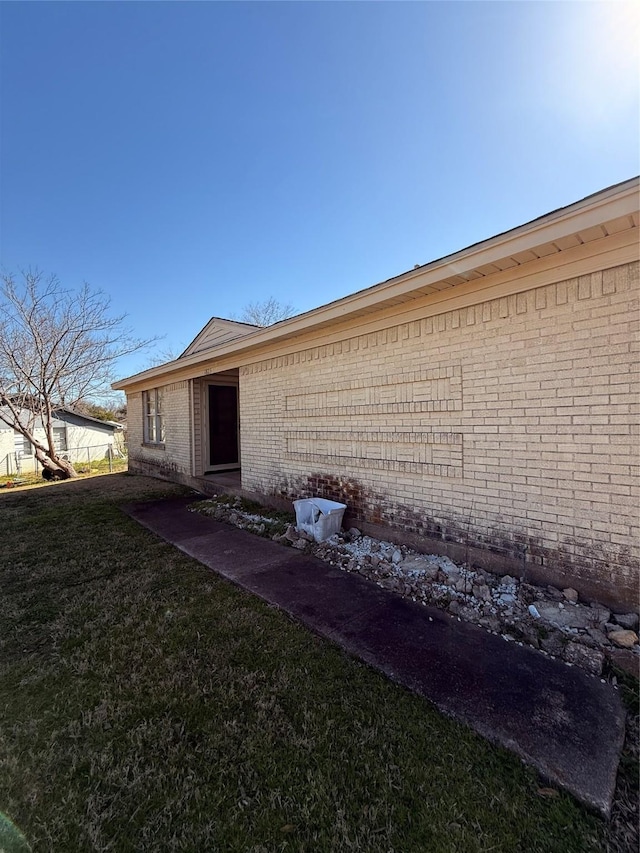 exterior space featuring a yard and brick siding