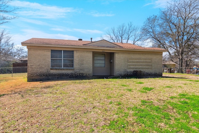 ranch-style house featuring brick siding, a front lawn, and fence