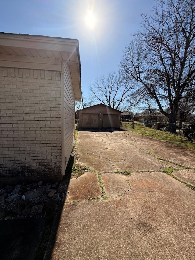 exterior space featuring a detached garage, an outbuilding, and brick siding