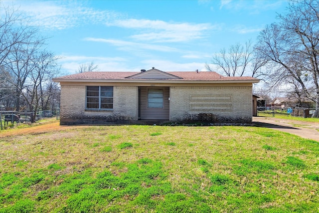 ranch-style home with brick siding, a front lawn, and fence