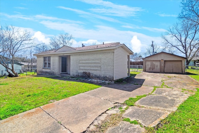 single story home with a front yard, fence, an outdoor structure, a detached garage, and brick siding