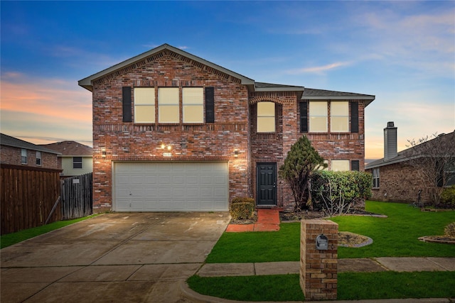 traditional-style house with brick siding, fence, concrete driveway, a garage, and a yard