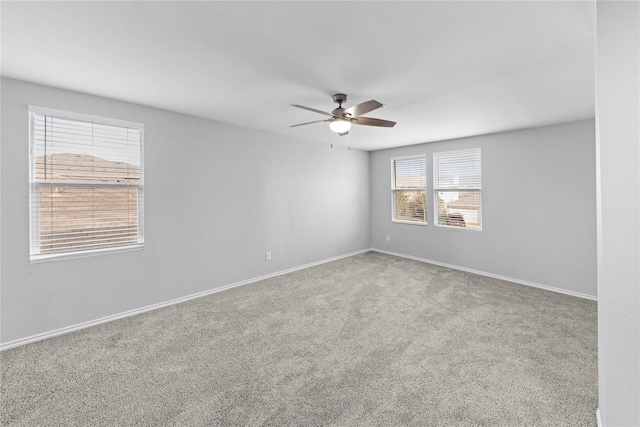 empty room featuring baseboards, carpet floors, and ceiling fan