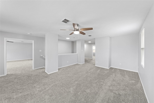 carpeted empty room featuring visible vents, recessed lighting, baseboards, and a ceiling fan