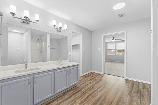 full bath with wood finished floors, a walk in shower, visible vents, and a sink