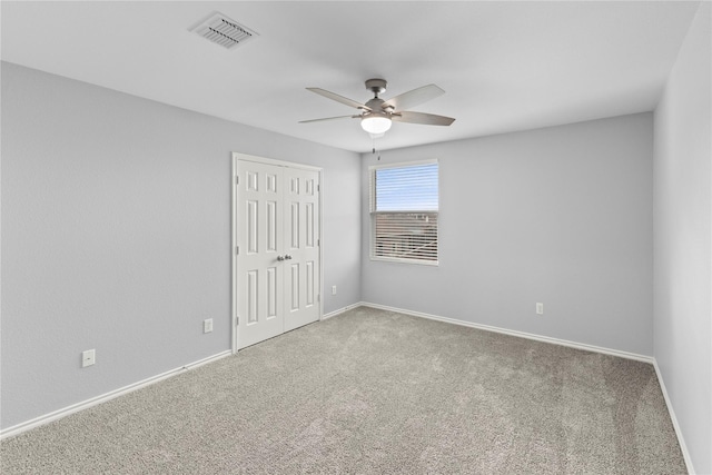 empty room featuring visible vents, baseboards, ceiling fan, and carpet floors