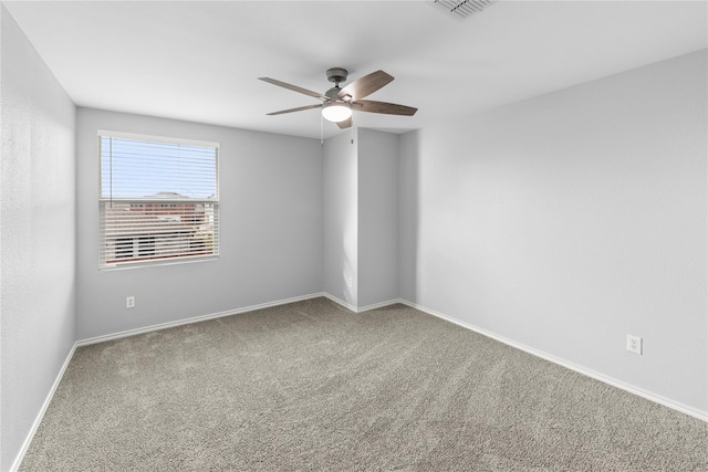 spare room featuring carpet flooring, baseboards, visible vents, and ceiling fan