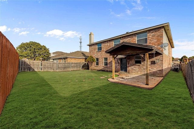 rear view of property featuring a yard, brick siding, and a patio area