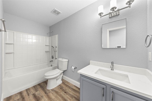 bathroom with vanity, wood finished floors, visible vents, toilet, and shower / bathtub combination