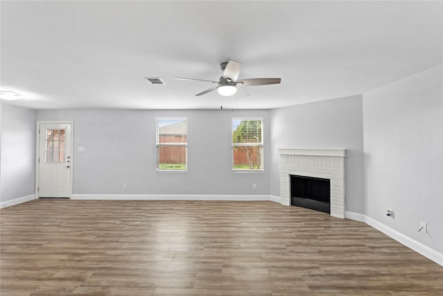 unfurnished living room with visible vents, wood finished floors, baseboards, and ceiling fan