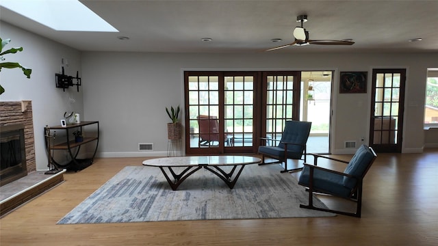 interior space with visible vents, baseboards, wood finished floors, and a fireplace