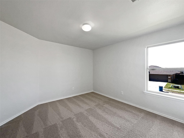 empty room featuring baseboards and carpet