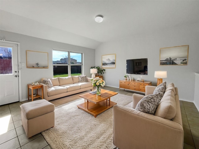 living room featuring tile patterned flooring, lofted ceiling, and baseboards