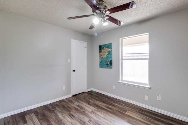 unfurnished room featuring ceiling fan, dark wood-style floors, baseboards, and a textured ceiling