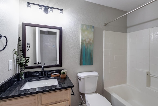 full bath featuring vanity, shower / bathing tub combination, toilet, and a textured wall