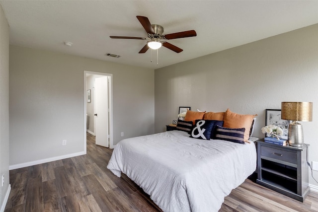 bedroom featuring ceiling fan, wood finished floors, visible vents, and baseboards