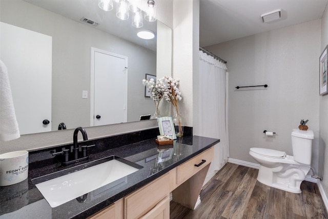 full bath with visible vents, curtained shower, toilet, wood finished floors, and vanity