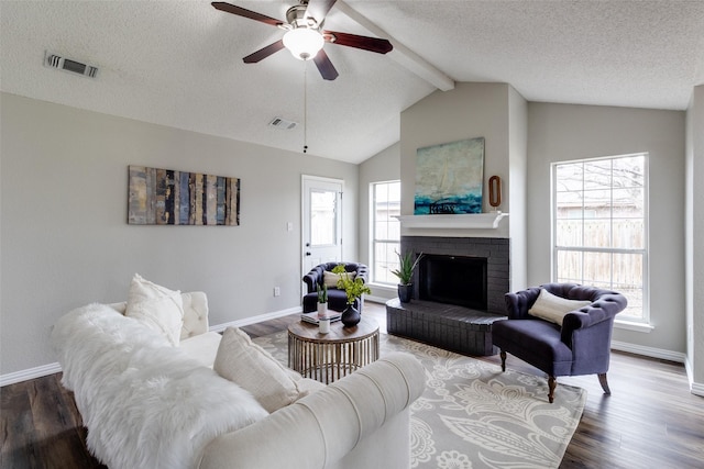 living room featuring wood finished floors, a healthy amount of sunlight, and visible vents