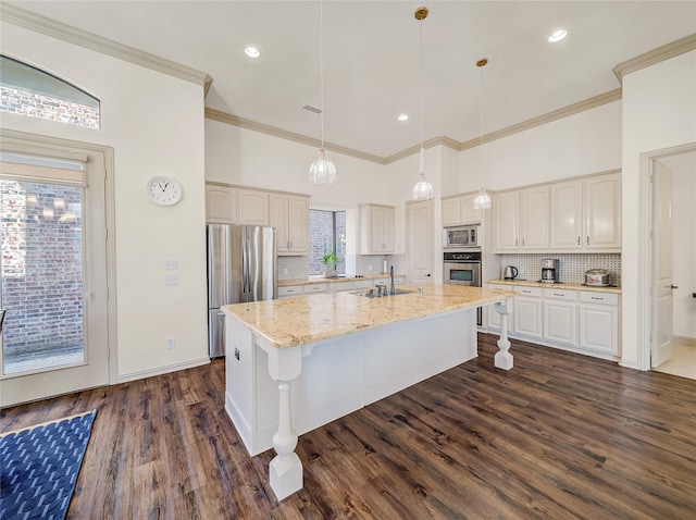 kitchen featuring light stone counters, dark wood-style floors, stainless steel appliances, a kitchen breakfast bar, and backsplash